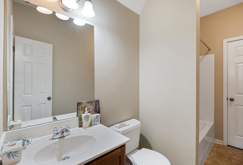 Bathroom featuring a vanity with an integrated white sink, chrome faucet, and wood-finish cabinetry