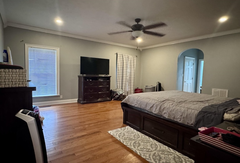 Spacious bedroom featuring wood-finish flooring, recessed lighting, and a ceiling fan