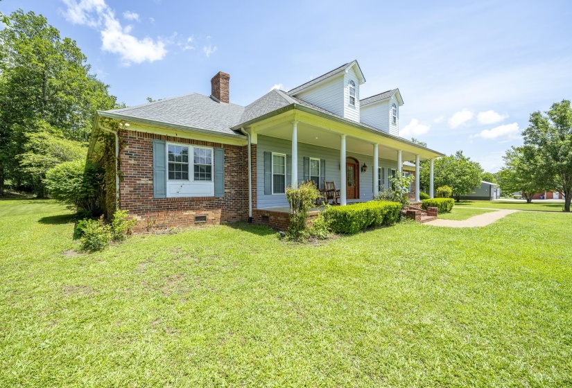 Two-story home featuring a combination brick and light blue siding exterior with a welcoming full-length covered porch