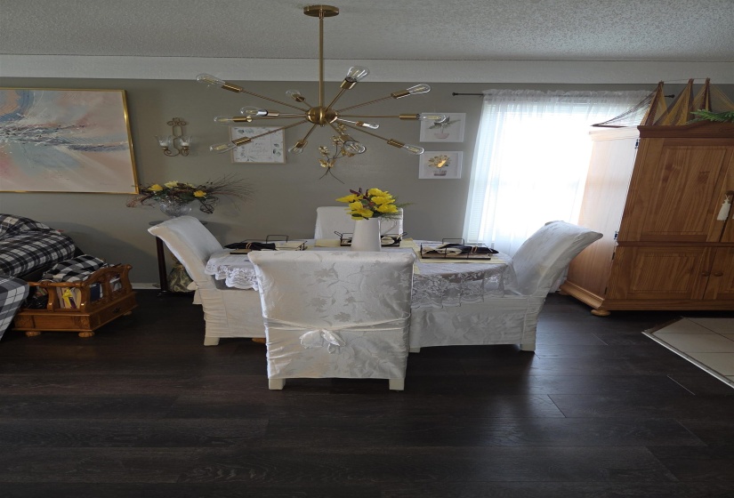 Dining area featuring wood-finish flooring and a contemporary chandelier