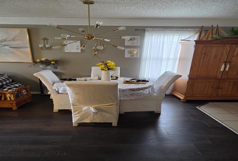 Dining area featuring dark wood-finish flooring and a contemporary gold sputnik chandelier