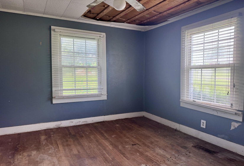 Wood-finish flooring throughout, complemented by two windows with horizontal blinds