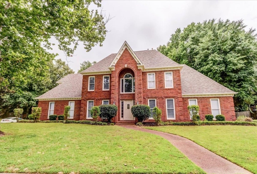 Brick exterior featuring a gabled roofline and arched window