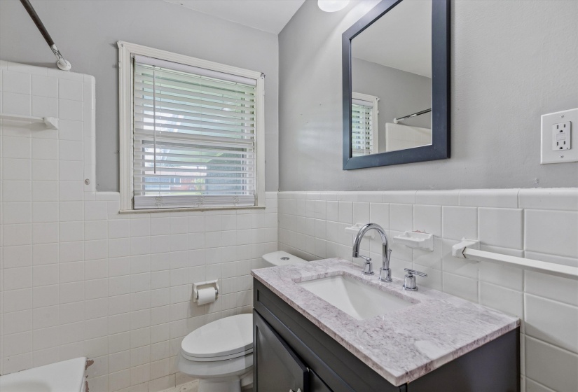 Bathroom vanity featuring a light-toned countertop, under-mount sink, and chrome fixtures