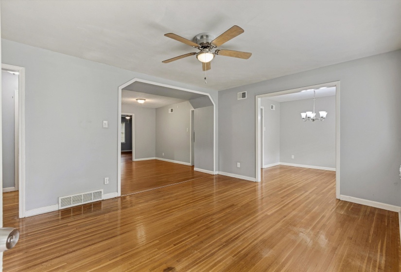 Spacious interior featuring wood-finish flooring, light gray walls, white trim, and an overhead ceiling fan