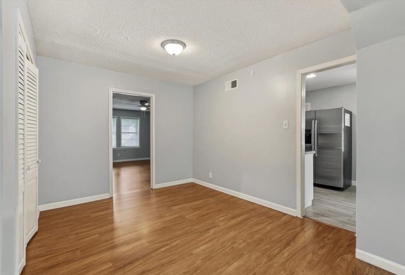 Room with wood-finish flooring, light gray walls, and white trim
