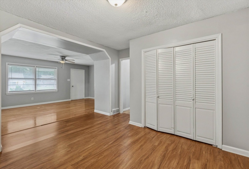 Room featuring wood-finish flooring, light gray wall paint, and white trim