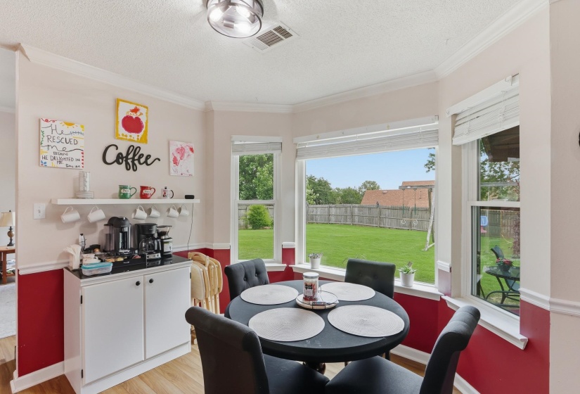 Dining area featuring a bay window with backyard visibility