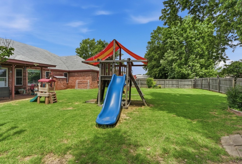 Expansive rear yard featuring green lawn and wood privacy fencing