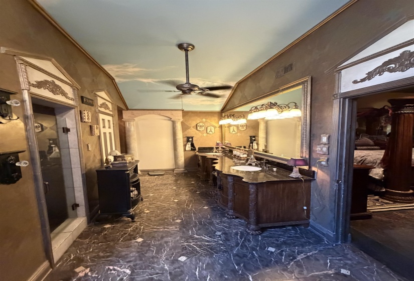 Spacious bathroom featuring a unique cloud-painted ceiling, large vanity with dual sinks, and a walk-in shower enclosure