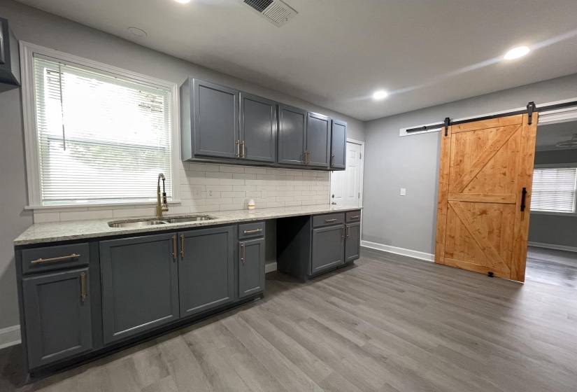 Kitchenette featuring dark gray cabinetry, white subway tile backsplash, and light-toned countertops