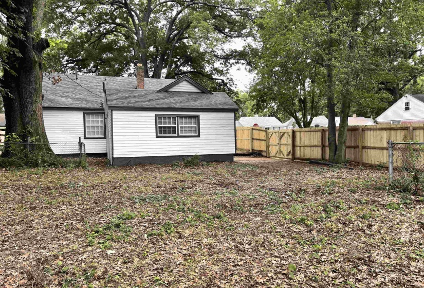 Expansive backyard area featuring a new privacy fence and gate