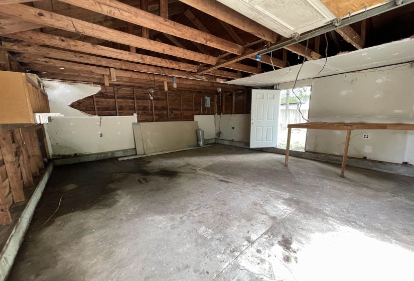 Interior space featuring exposed wood ceiling joists and wall studs