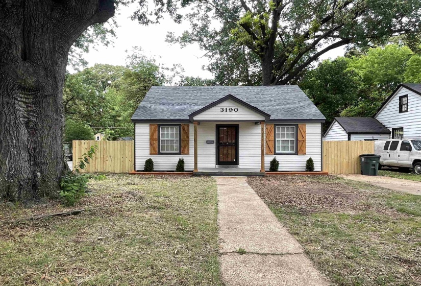 White siding exterior with a dark shingle roof and wood shutters
