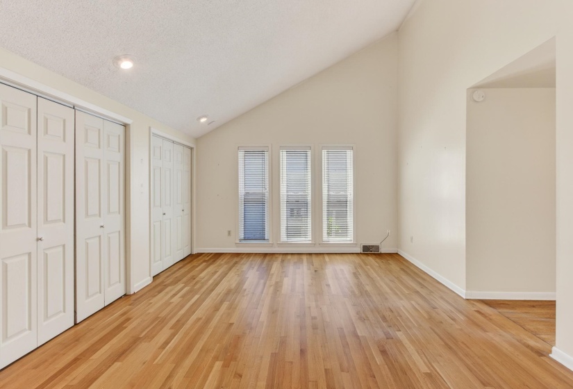 Featuring rich hardwood floors and striking ceilings, this primary bedroom is filled with both warmth and modern character.