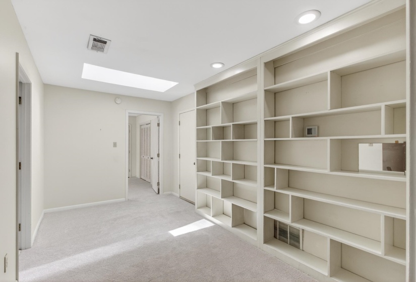 The loft space features a wall of custom built-ins, and plenty of space for children to have a play area or a reading room!  Walk-in attic space can be accessed from this room as well as the full bathroom upstairs.