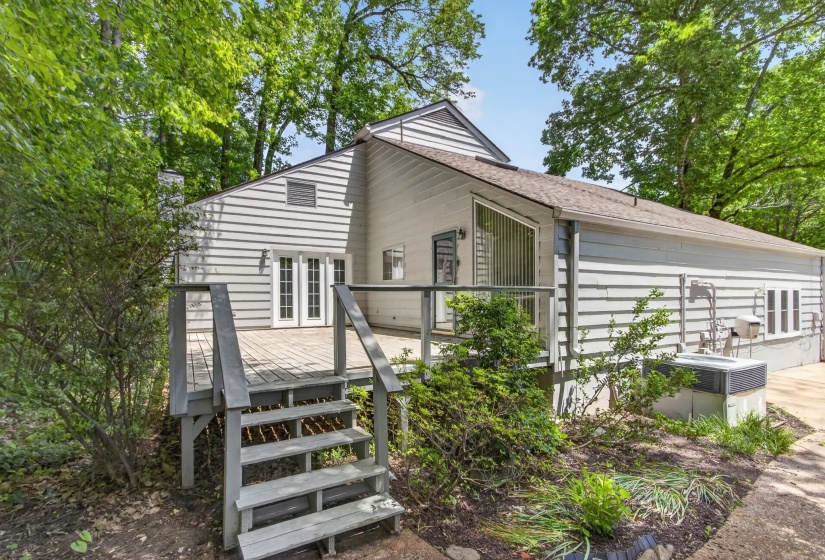 The spacious rear deck, surrounded by lush natural scenery, creates a peaceful outdoor retreat perfect for relaxing or entertaining.