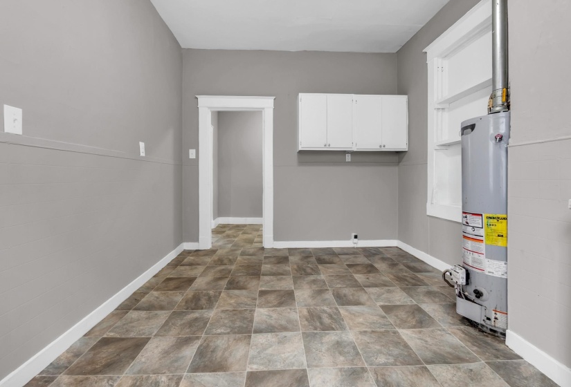 Room featuring patterned tile flooring, neutral gray walls, and white trim