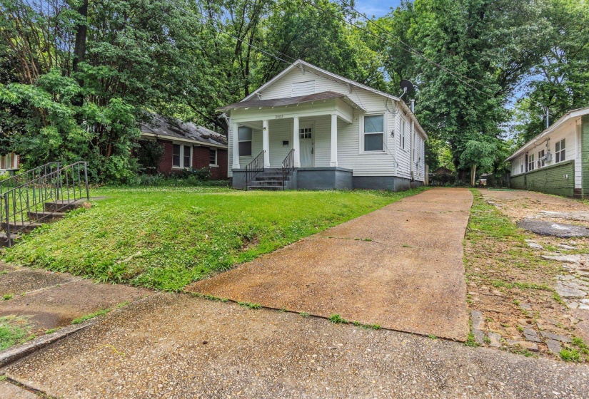 White-sided residence featuring a covered front porch and a paved driveway