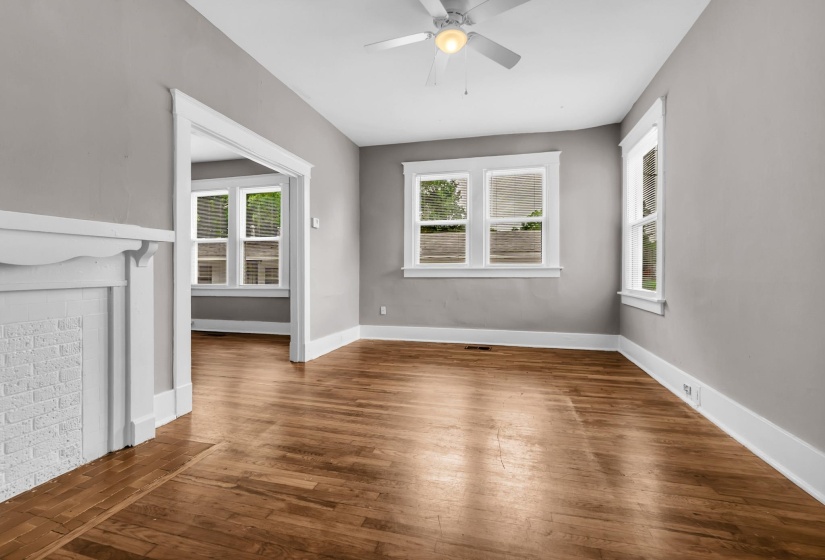 Spacious room featuring wood-finish flooring, light grey walls, and white trim