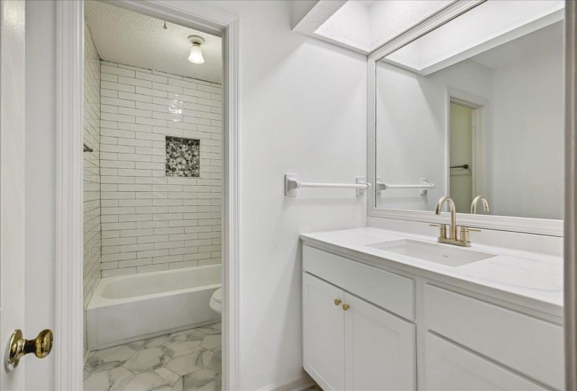 Bathroom vanity featuring a single basin, brushed nickel faucet, and a large wall-mounted mirror