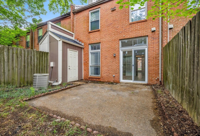 Private outdoor patio area bordered by a wood fence