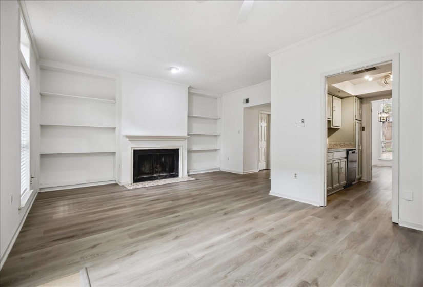 Bright living space featuring wood-finish flooring and a fireplace with a white mantel