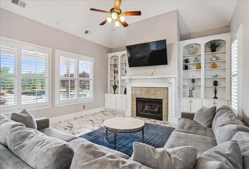 Living area featuring a vaulted ceiling and a ceiling fan