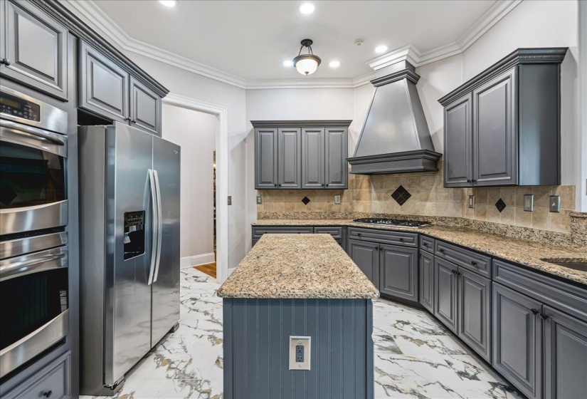 Kitchen featuring white marble-look flooring, gray cabinetry, and granite countertops