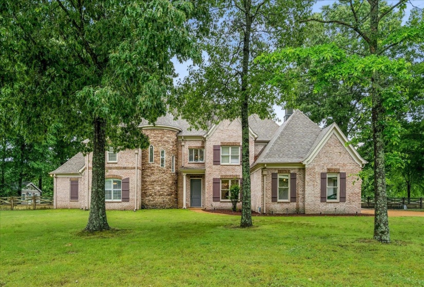 Brick exterior with a prominent turret, multiple gables, and dark shutters