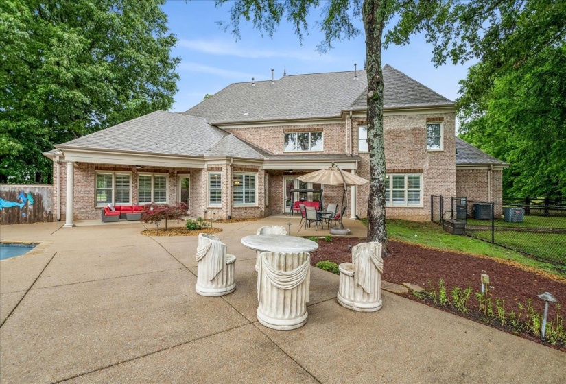 Brick exterior featuring multiple windows and a covered patio