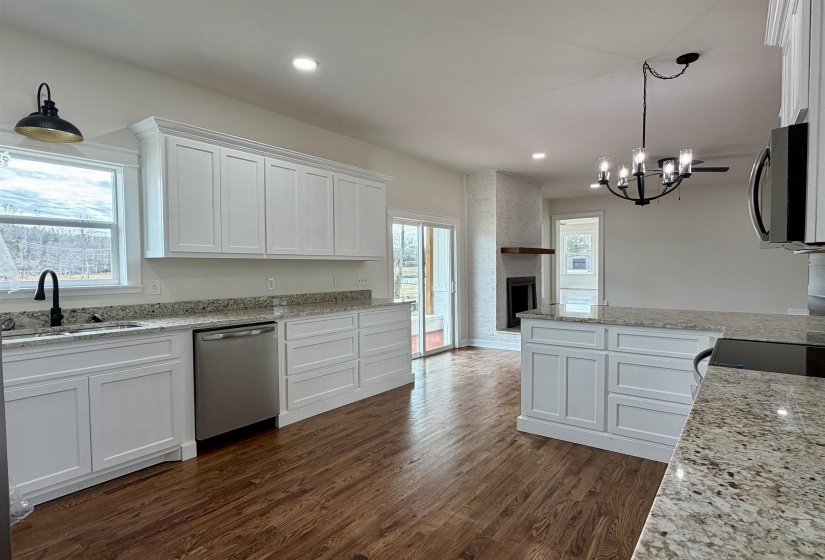 Kitchen featuring white cabinetry, light stone countertops, stainless steel appliances, and dark wood finished floors