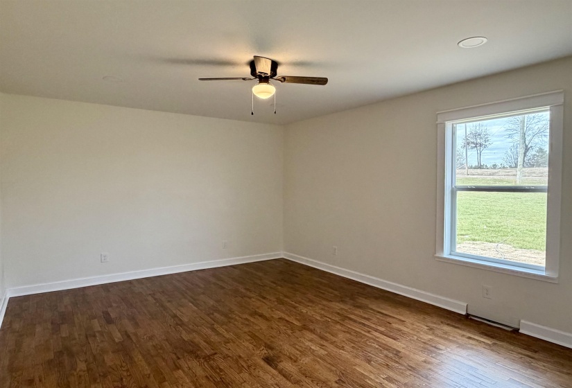 Unfurnished room with dark wood-style floors and ceiling fan
