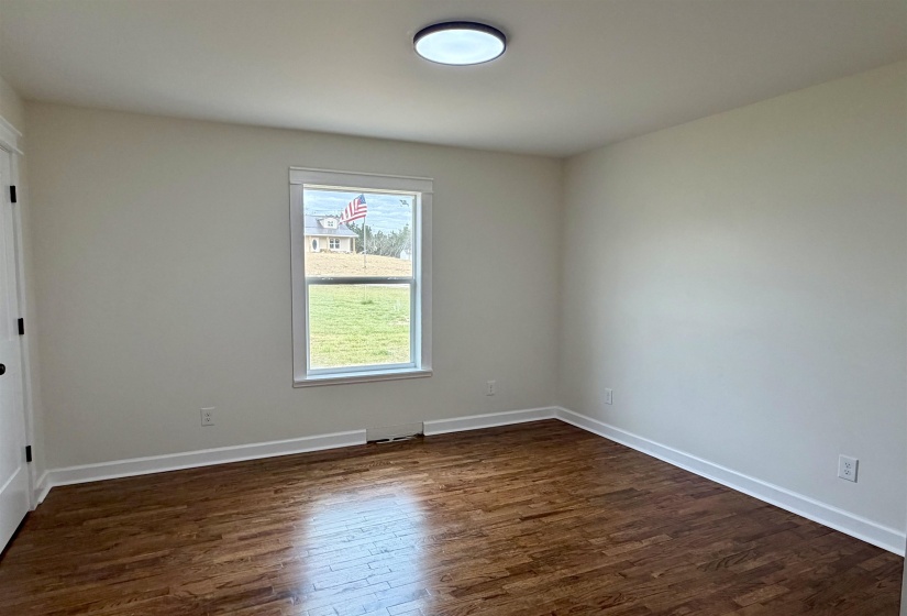 Empty room with dark wood-style flooring and baseboards