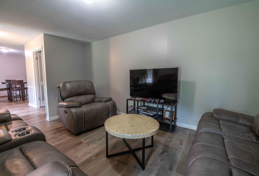 Living area featuring wood-finish flooring, light gray wall paint, and white trim