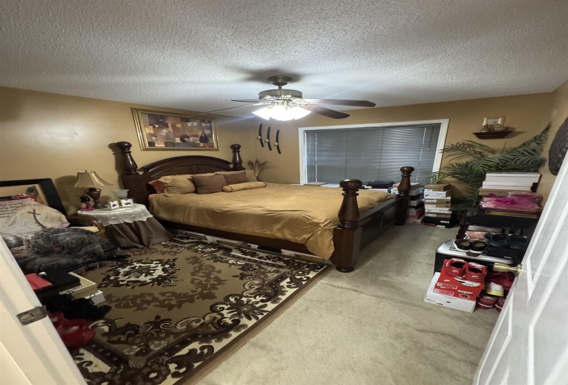 Spacious room featuring neutral carpeting and warm-toned wall paint