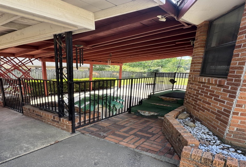 Brick exterior with an attached covered patio featuring a dark wood-finish ceiling