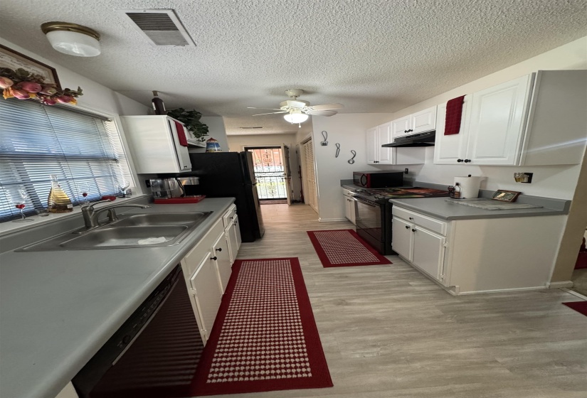 Kitchen featuring white cabinetry, gray countertops, and wood-finish flooring