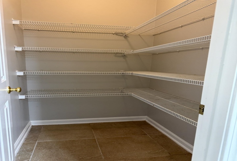 Walk-in closet featuring wire shelving, tile flooring, and neutral wall paint