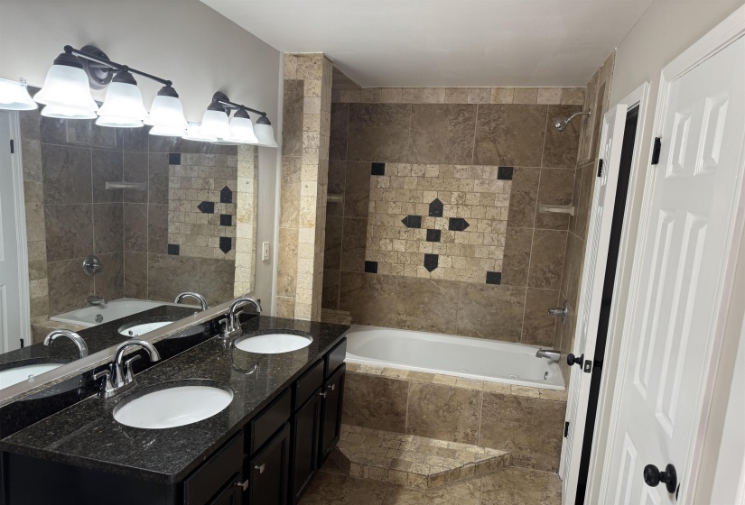 Bathroom featuring vanity and tiled shower / bath