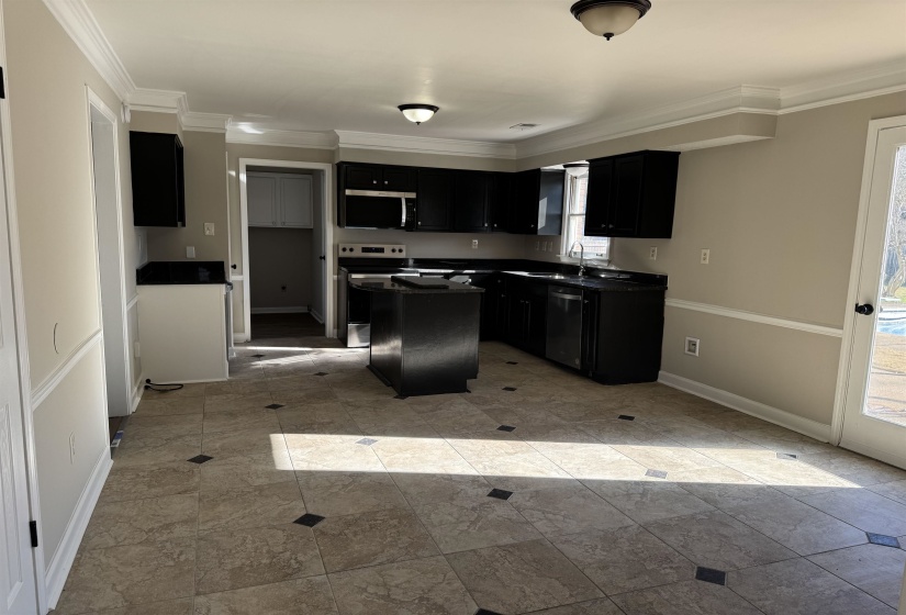 Kitchen featuring sink, a kitchen island, stainless steel appliances, and ornamental molding