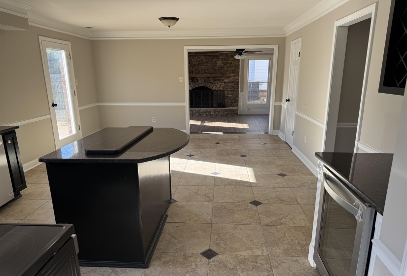 Kitchen with a kitchen island, crown molding, a healthy amount of sunlight, and a fireplace
