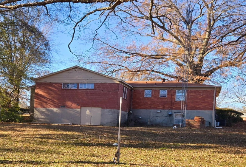 View of property exterior featuring brick siding and a lawn