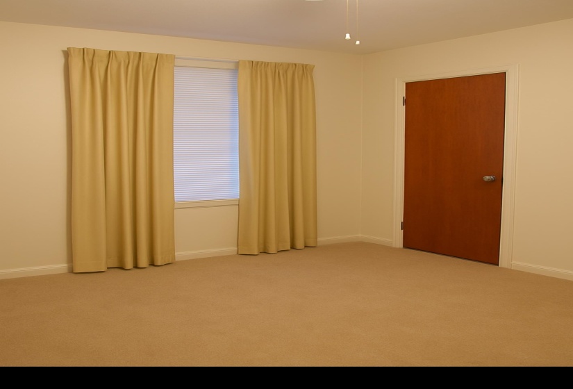 Carpeted empty room featuring baseboards