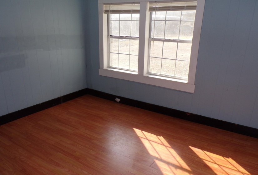 Spare room with dark wood-style flooring and wooden walls