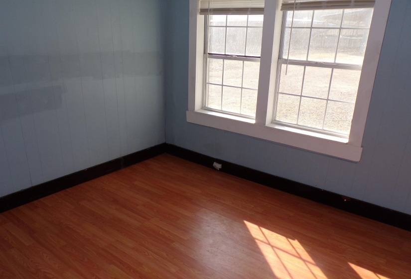 Empty room with dark wood-style floors and wooden walls