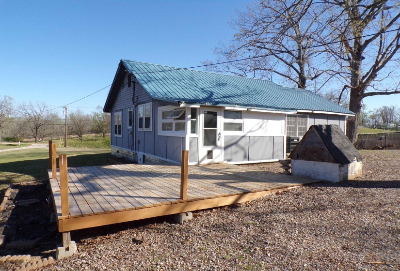 Rear view of property with a wooden deck, a metal roof, and board and batten siding