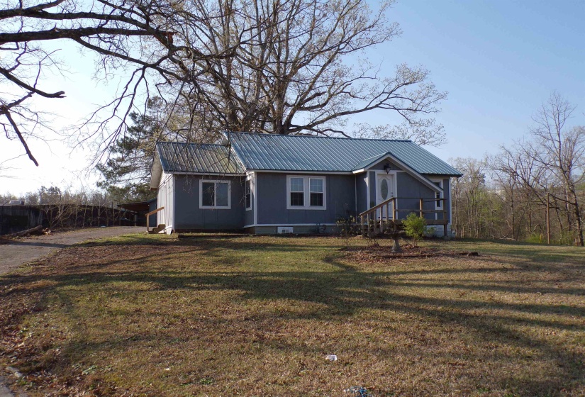 View of front facade with a metal roof and a front lawn