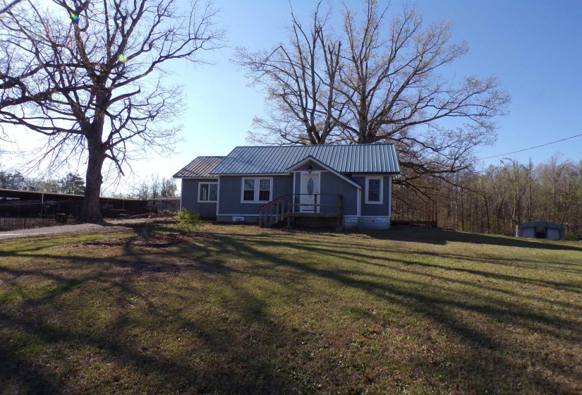 View of front of house featuring crawl space, a metal roof, and a front lawn
