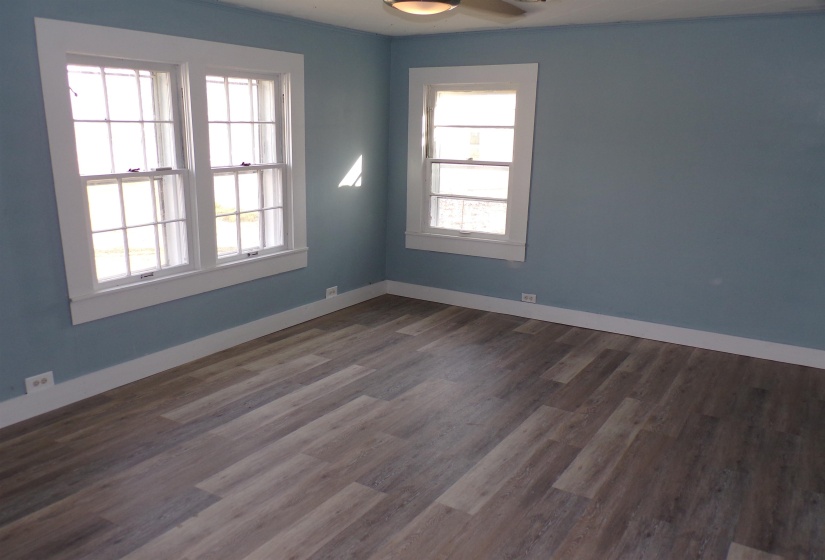 Spare room with dark wood-style flooring and baseboards